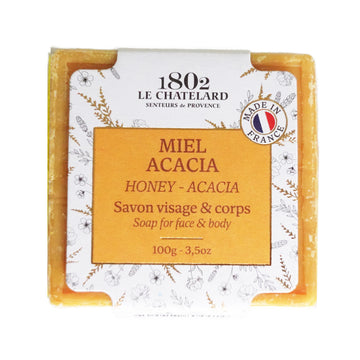 Soap bar with packaging labeled '1802 Le Chatelard' for face and body, featuring honey and acacia scents.