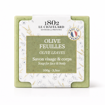 Green soap bar with white packaging featuring branding and product details on a white background