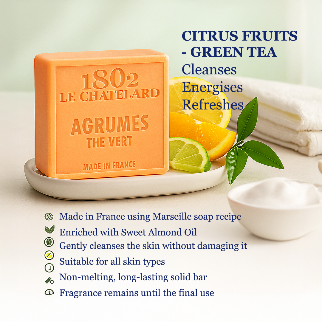 Orange soap bar with branding and product details on a white surface with citrus fruits.
