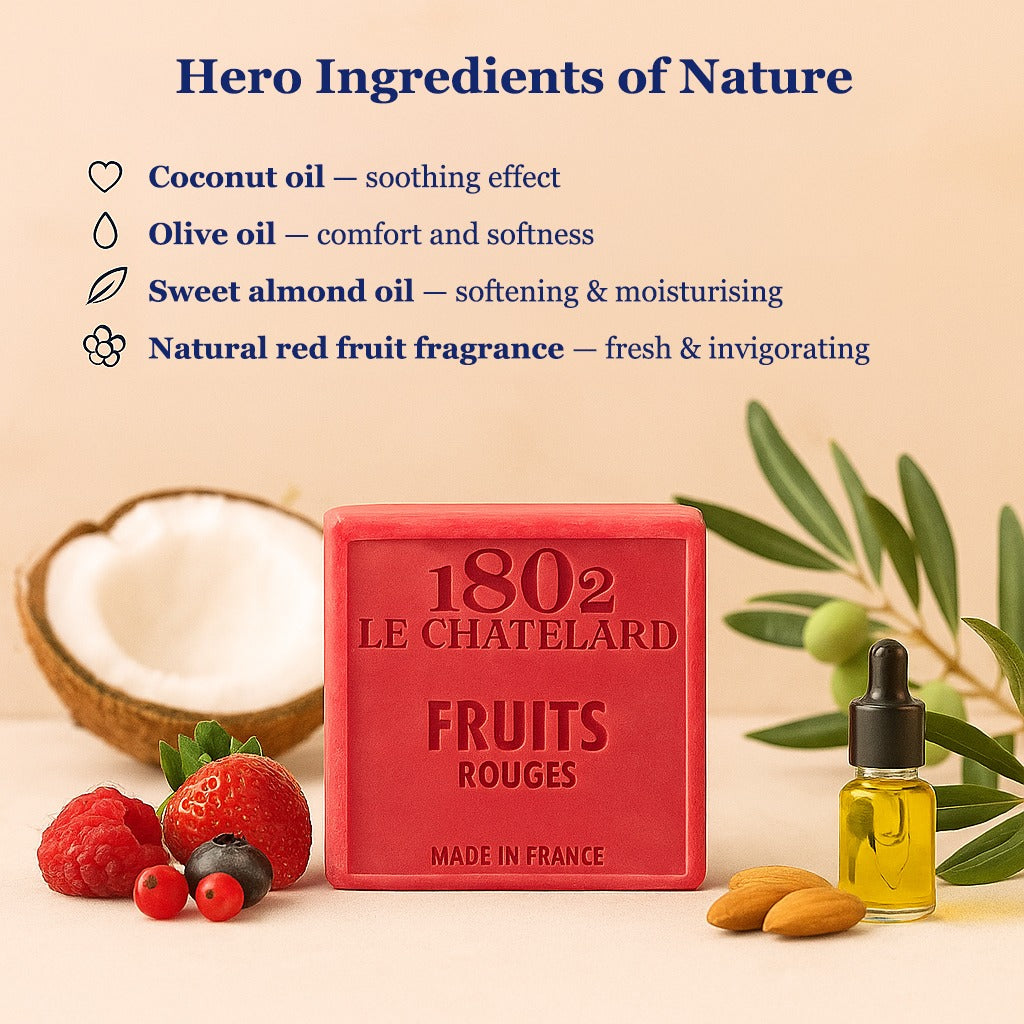 Red soap bar with '1802 Le Chateletard' branding, surrounded by fruits and a bottle of oil on a beige background.