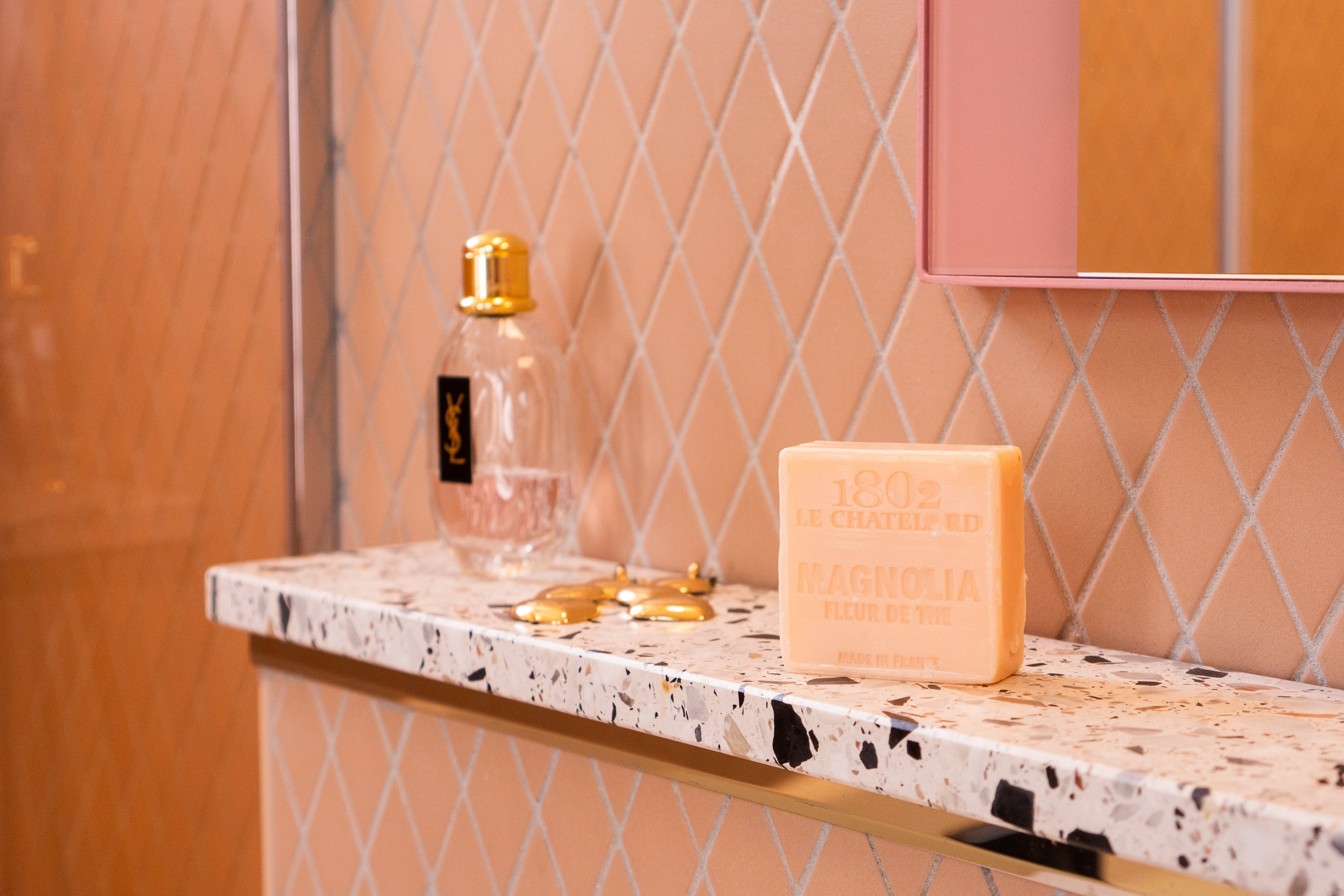 Decorative items on a marble countertop with a patterned wall in the background