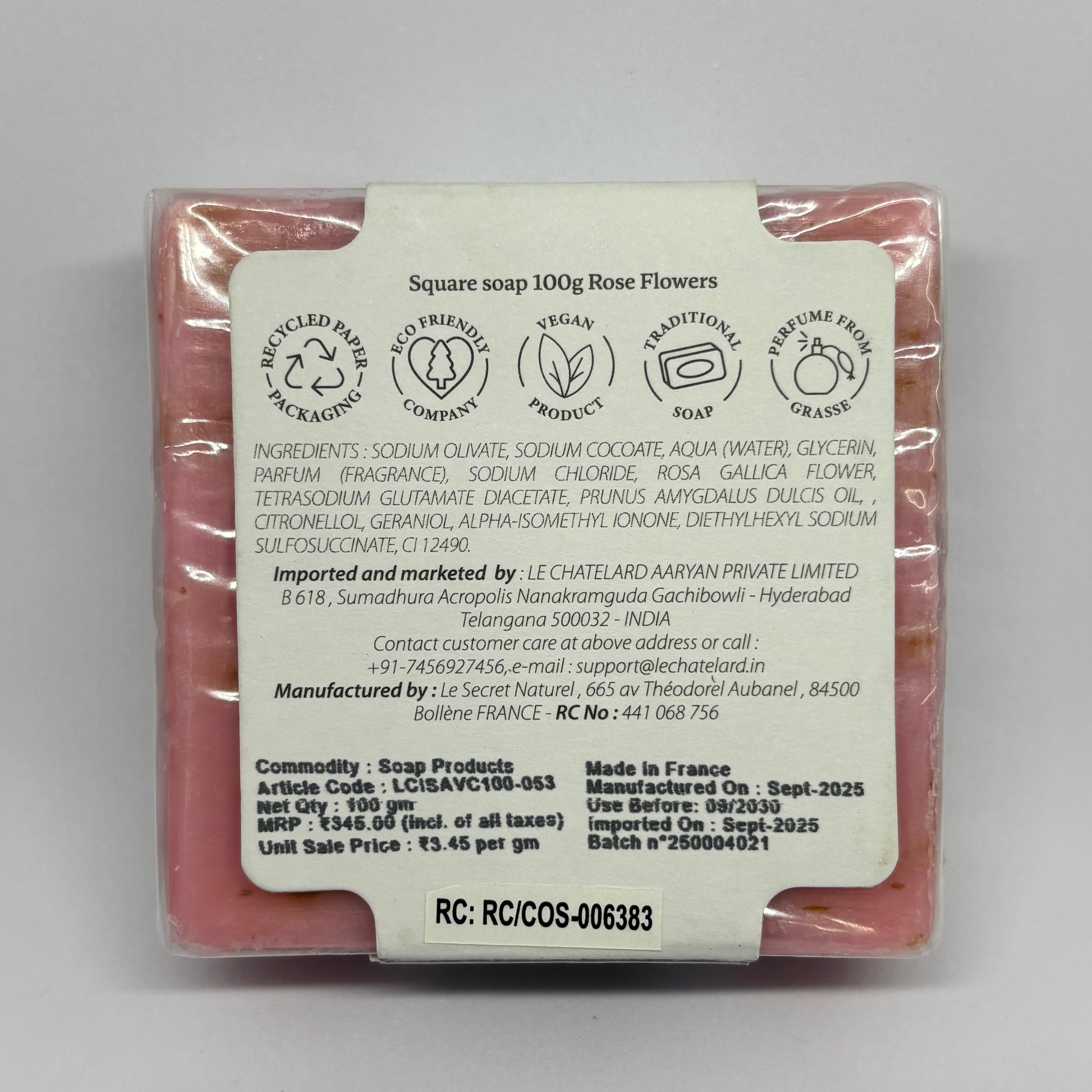 Square soap with a label detailing ingredients and manufacturing information on a gray background