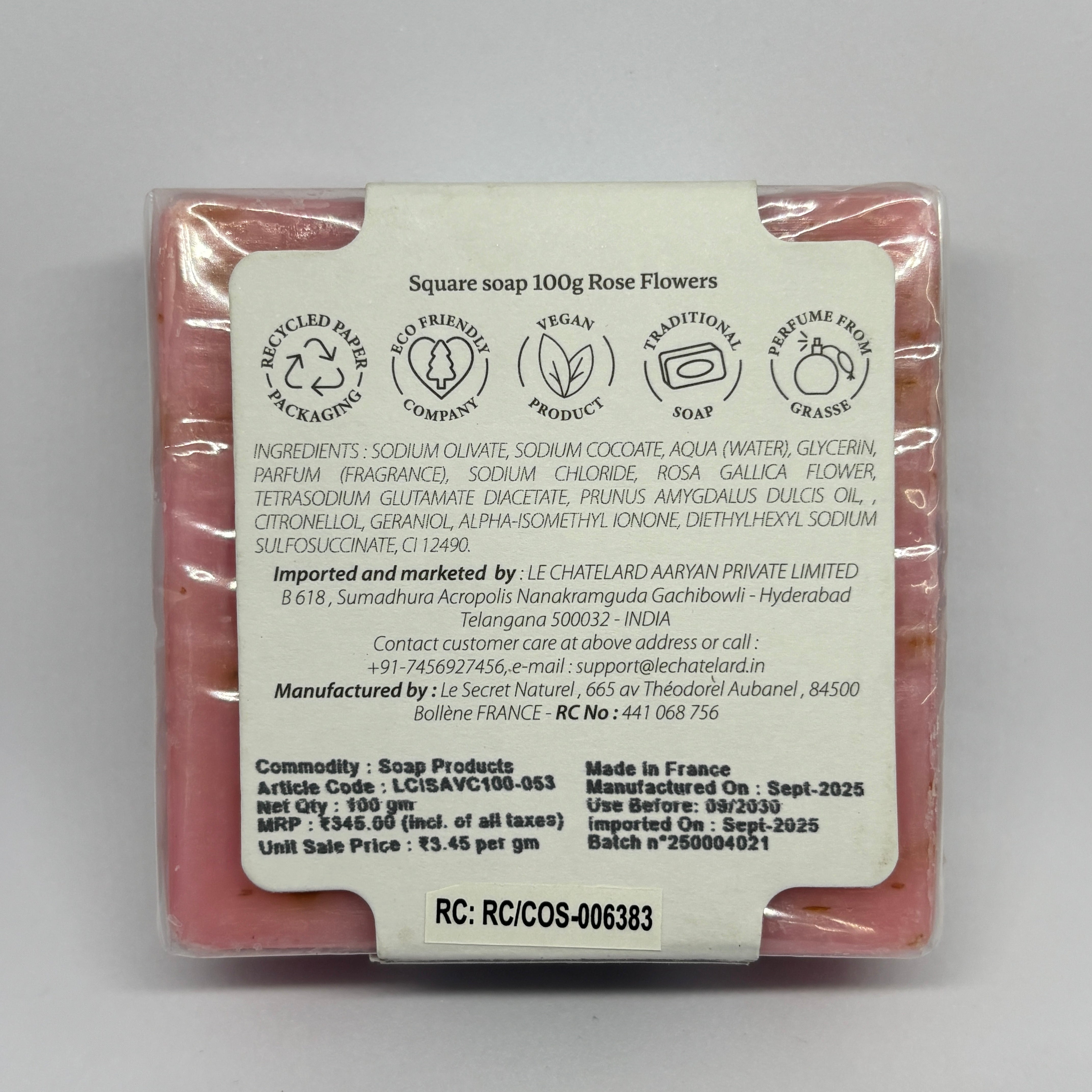 Square soap with a label detailing ingredients and manufacturing information on a gray background