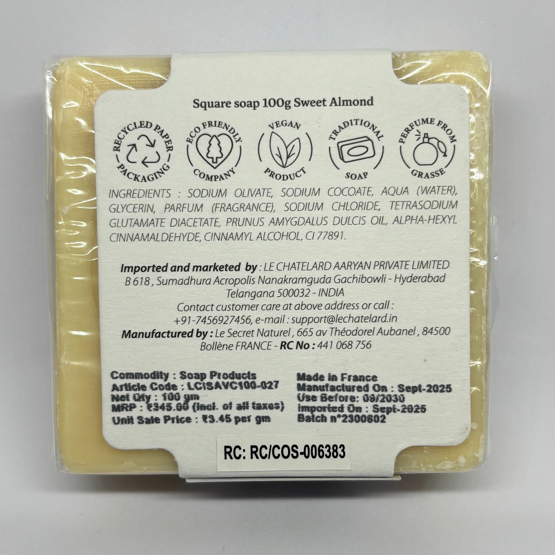 Back view of a sweet almond soap bar with packaging details on a gray background