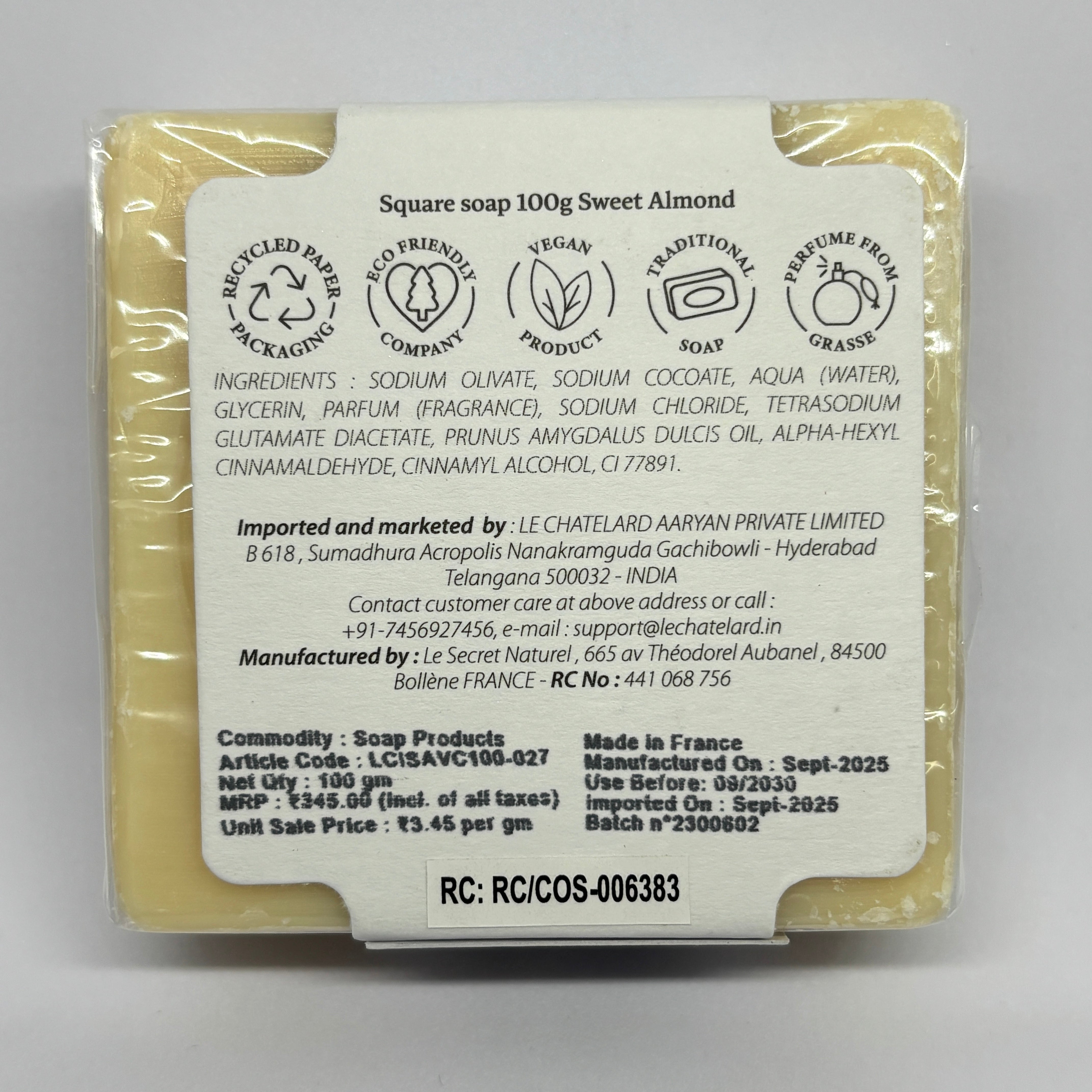 Back view of a sweet almond soap bar with packaging details on a gray background